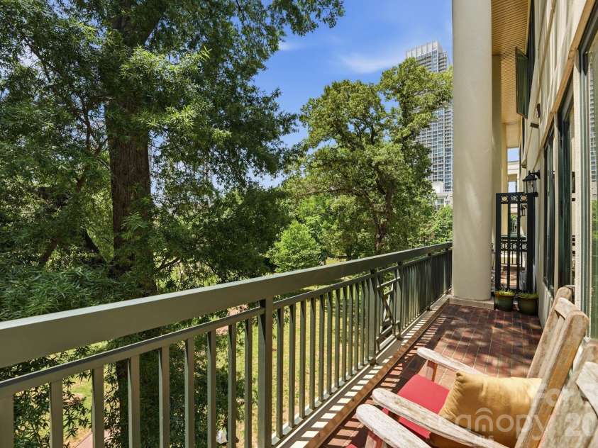 229 Church Street, Charlotte, NC 28202.  MLS# CAR4381312, YatesRealty ID 3818. Expansive covered terrace overlooking mature trees and Fourth Ward Park, offering a rare blend of privacy, greenery, and Uptown living. Ideal for outdoor dining, entertaining, or relaxing year round.