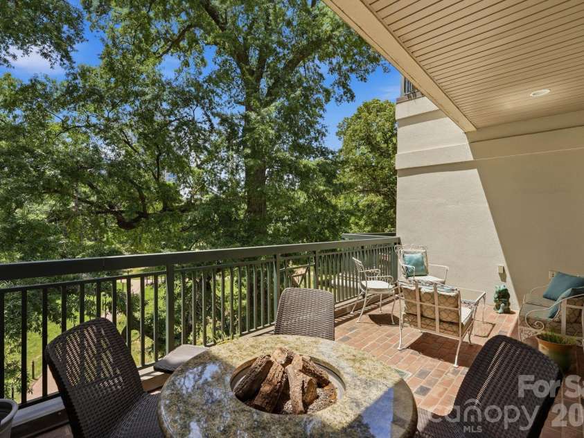 229 Church Street, Charlotte, NC 28202.  MLS# CAR4381312, YatesRealty ID 3818. Private covered balcony overlooking Fourth Ward Park and Uptown greenery, creating a peaceful outdoor extension of the home.