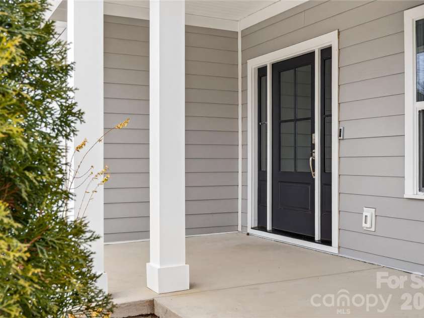 126 Meadow Glen Drive, Troutman, NC 28166.  MLS# CAR4340501, YatesRealty ID 3819. Covered Front Porch With concrete surface and white columns. 