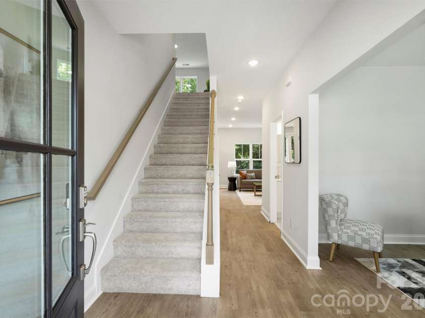 126 Meadow Glen Drive, Troutman, NC 28166.  MLS# CAR4340501, YatesRealty ID 3819. Light filled entry with glass front door, staircase, and sightlines through the home to the main living area.