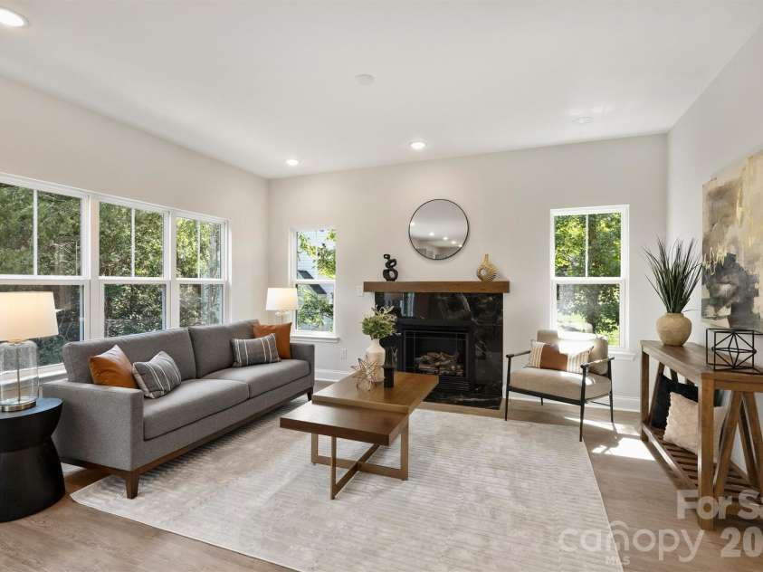 126 Meadow Glen Drive, Troutman, NC 28166.  MLS# CAR4340501, YatesRealty ID 3819. Open concept living room featuring large windows, gas fireplace, and an open floor plan that adjoins the kitchen.