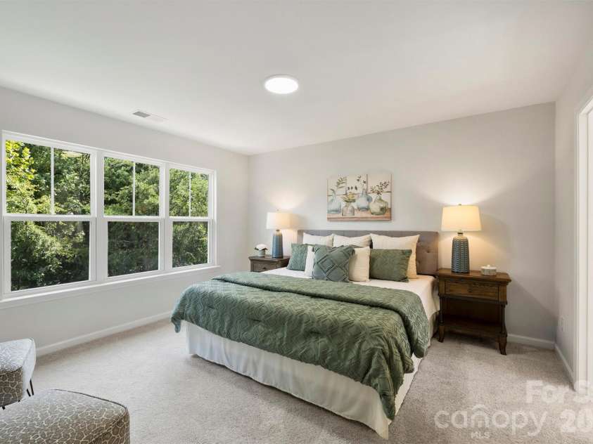 126 Meadow Glen Drive, Troutman, NC 28166.  MLS# CAR4340501, YatesRealty ID 3819. Primary bedroom featuring large windows and an ensuite bathroom