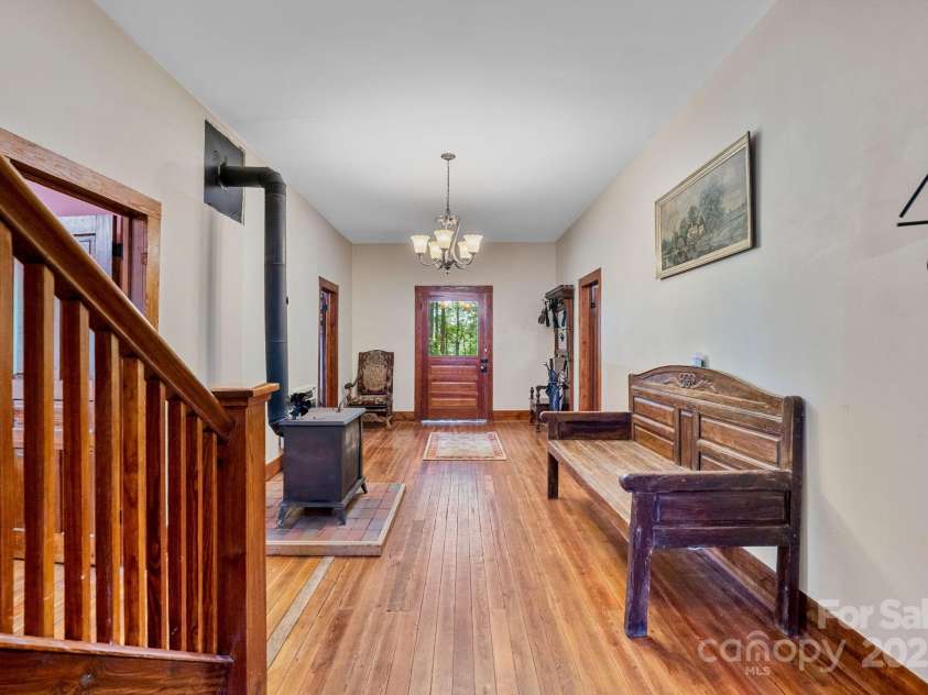 305 Ficker Circle, Hendersonville, NC 28739.  MLS# CAR4240043, YatesRealty ID 3831. Main-level foyer looking toward front door. Stove is original to house; was restored and moved to foyer and is operational.