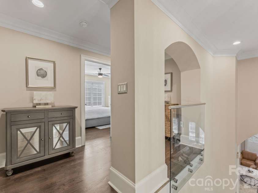 17411 Summer Place Drive, Cornelius, NC 28031.  MLS# CAR4401453, YatesRealty ID 38428. Upper hallway with arched openings, console styling, and natural light.