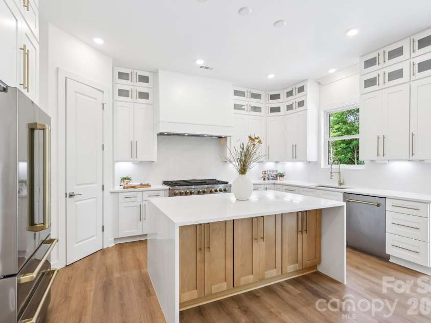 332 Point Carpenter Road, Indian Land, SC 29707.  MLS# CAR4393958, YatesRealty ID 38464. Stunning chef's kitchen featuring high-end quartz countertops with a matching waterfall backsplash. This gourmet space includes a large walk-in pantry, a premium Z-Line 48-inch dual-fuel gas range, stainless ste