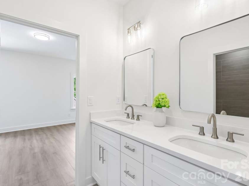 332 Point Carpenter Road, Indian Land, SC 29707.  MLS# CAR4393958, YatesRealty ID 38464. This jack-and-jill bathroom features durable tile flooring and a coordinating tiled tub/shower surround. The functional layout includes a dual-sink vanity, while the tub and toilet area are separated from the va