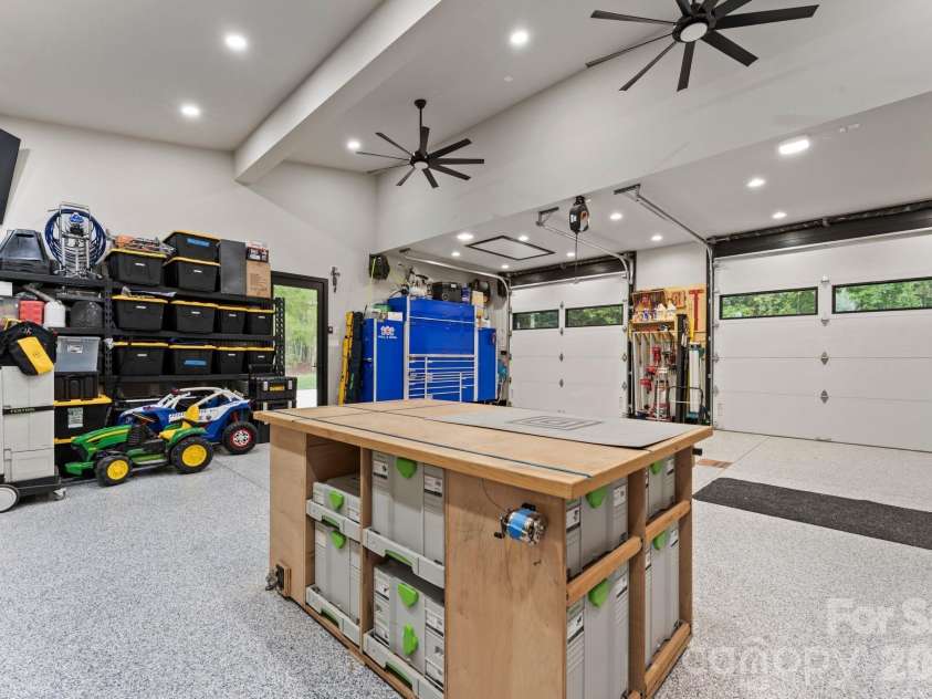 1064 Greylyn Drive, Matthews, NC 28104.  MLS# CAR4399475, YatesRealty ID 38492. Climate-controlled finished garage with EV charging, epoxy-style polyaspartic floors, and workshop features