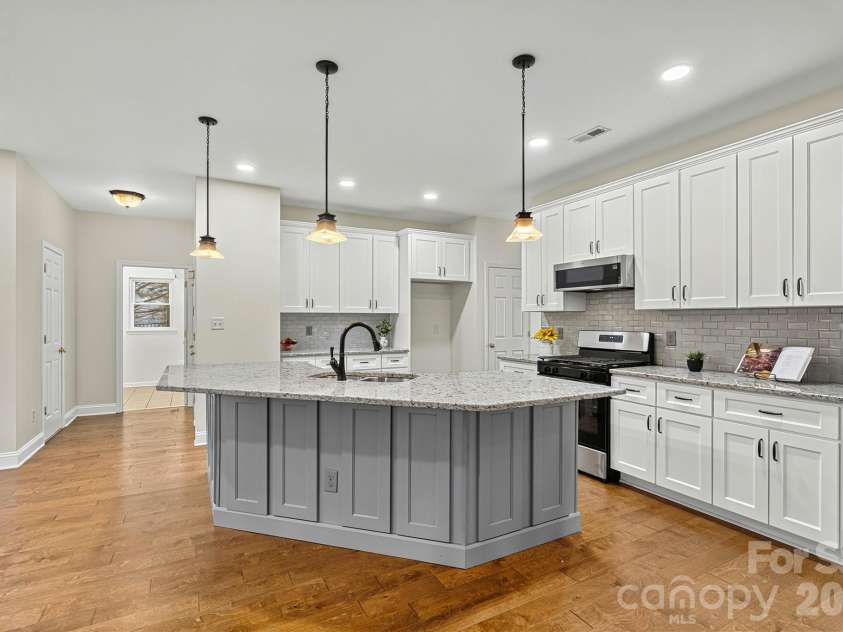 7542 Sedgebrook Drive, Stanley, NC 28164.  MLS# CAR4401228, YatesRealty ID 38497. White kitchen w/ large island and quartz countertop