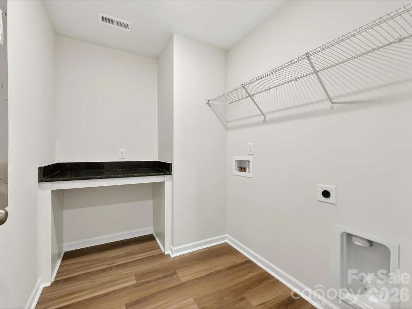 250 Alluvium Lane, Waxhaw, NC 28173.  MLS# CAR4332178, YatesRealty ID 38517. Laundry features folding table with granite countertop