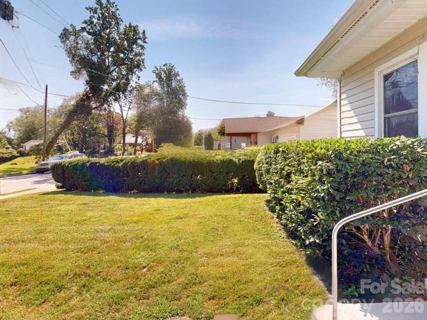 331 Probart Street, Brevard, NC 28712.  MLS# CAR4405723, YatesRealty ID 38535. Front Yard – Level front yard with mature landscaping and established hedges, creating an attractive streetscape and welcoming curb appeal.