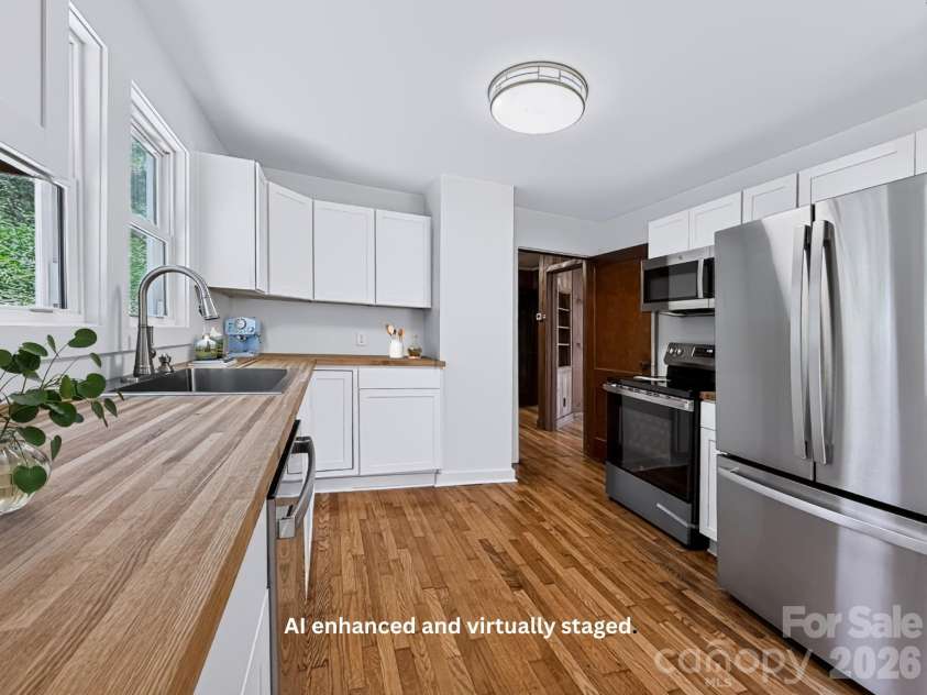 331 Probart Street, Brevard, NC 28712.  MLS# CAR4405723, YatesRealty ID 38535. Kitchen – Bright, updated kitchen featuring white shaker cabinetry, butcher block countertops, stainless steel appliances, and beautiful hardwood floors.