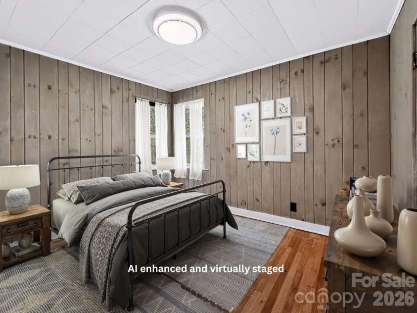 331 Probart Street, Brevard, NC 28712.  MLS# CAR4405723, YatesRealty ID 38535. Second Bedroom – Bright and inviting second bedroom featuring hardwood floors, charming painted wood-paneled walls, and corner windows that bring in abundant natural light.