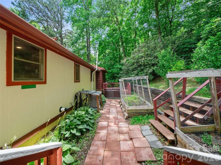 125 Heartland Lane, Burnsville, NC 28714.  MLS# CAR4273356, YatesRealty ID 3871. Behind house, Hot Tub, Garden beds, Landscape