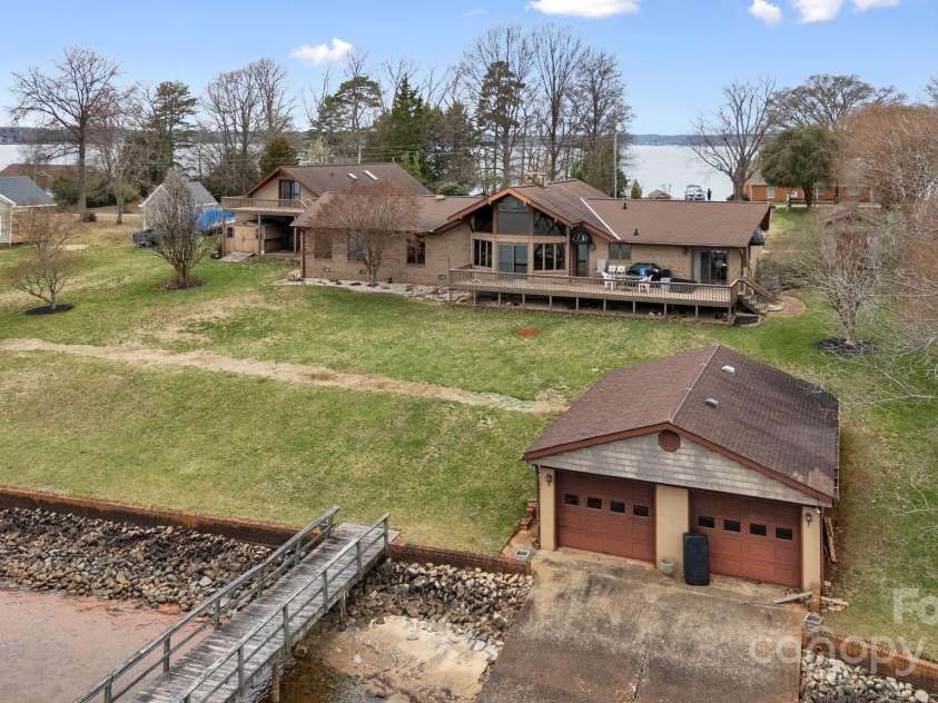 167 Points End Drive, Mooresville, NC 28117.  MLS# CAR4230820, YatesRealty ID 3879. Backyard view of home: double boathouse, dock entrance, and nice flat property