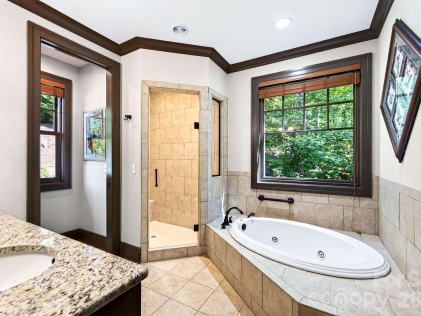 33 Hawks Branch Circle, Fairview, NC 28730.  MLS# CAR4403173, YatesRealty ID 38919. Primary bath with soaking tub overlooking the wooded setting