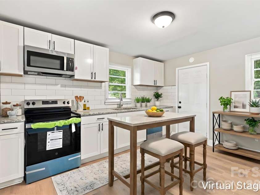 3708 Carlyle Drive, Charlotte, NC 28208.  MLS# CAR4405465, YatesRealty ID 39109. Walking into your upgraded kitchen. Highlights include granite counters, shaker-style cabinets, included SS appliances (dishwasher, electric range & microwave), subway tile backsplash & SS deep sink (virtually staged & 
