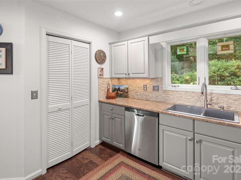 270 Ridge Drive, Saluda, NC 28773.  MLS# CAR4132159, YatesRealty ID 3919. Kitchen has a large pantry. Kitchen window looks out to landscaped yard, and you can see guests arrive.