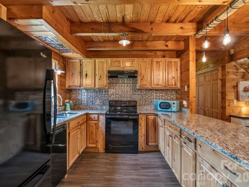4551 Lake Adger Parkway, Mill Spring, NC 28756.  MLS# CAR4401928, YatesRealty ID 39249. Kitchen has ample cabinets plus tin backsplash/accents for added charm