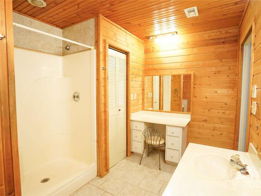 262 Rooster Cove, Brevard, NC 28712.  MLS# CAR4292738, YatesRealty ID 39326. Large bathroom with shower, whirlpool tub, double vanity, and large linen closet off of large main level bedroom