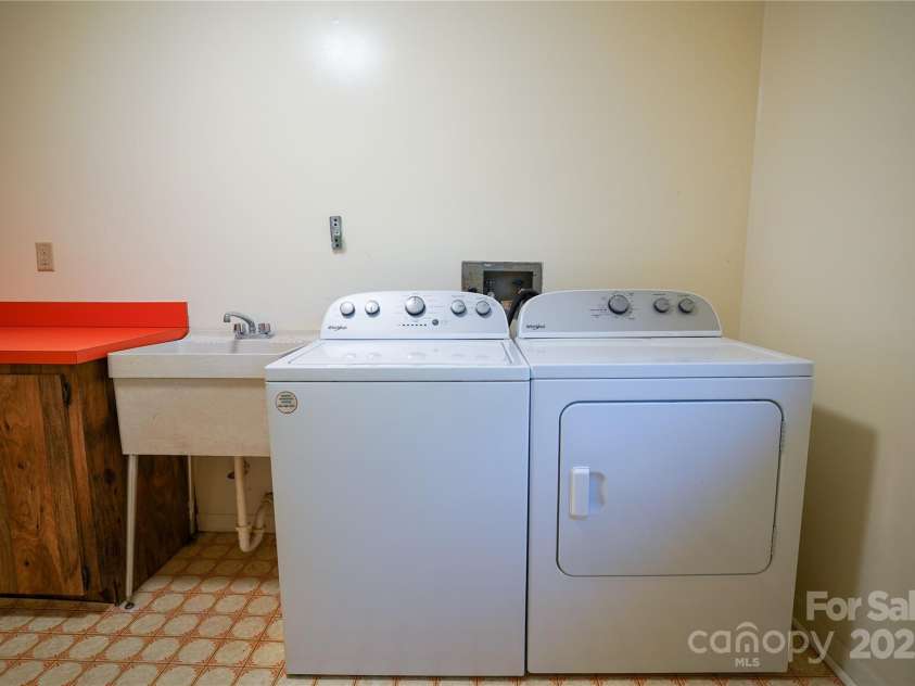 262 Rooster Cove, Brevard, NC 28712.  MLS# CAR4332799, YatesRealty ID 39326. Main level laundry room w/ deck access, utility sink, folding area, fold down ironing board, large closet, washer and dryer