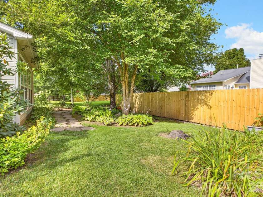 171 Running Briar Road, Fletcher, NC 28732.  MLS# CAR4403856, YatesRealty ID 39536. Back yard flower beds and greenery