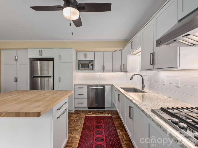 65 Cliff Drive, Laurel Park, NC 28739.  MLS# CAR4394753, YatesRealty ID 39607. Another view of the thoughtfully designed second kitchen highlights its abundant cabinetry, generous workspace, and seamless connection to the lower-level living area.