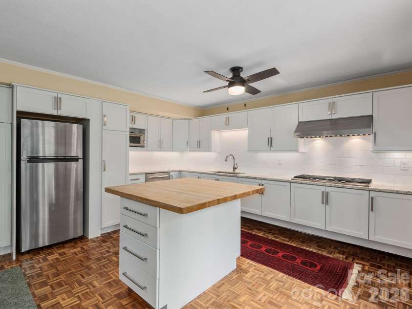65 Cliff Drive, Laurel Park, NC 28739.  MLS# CAR4394753, YatesRealty ID 39607. Designed for flexibility, the lower-level kitchen offers abundant storage, a functional layout, and a center island for meal prep and gathering