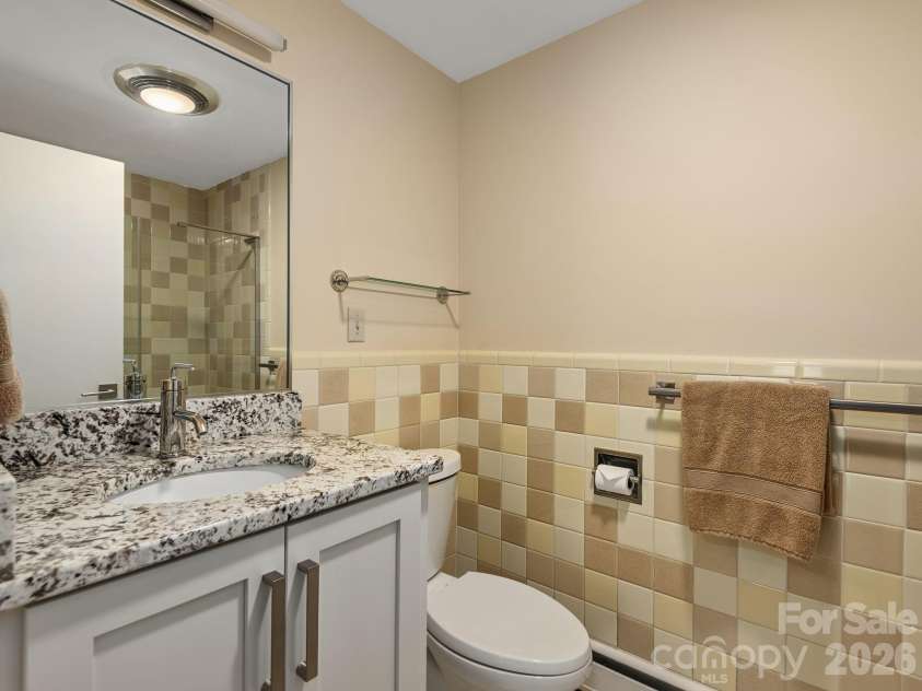 65 Cliff Drive, Laurel Park, NC 28739.  MLS# CAR4394753, YatesRealty ID 39607. One of two full baths on the lower level, this bath blends original mid-century tile with tasteful modern updates
