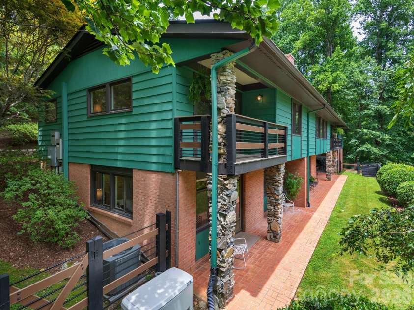 65 Cliff Drive, Laurel Park, NC 28739.  MLS# CAR4394753, YatesRealty ID 39607. The rear elevation highlights multiple outdoor living spaces, including a Juliet balcony off the primary suite