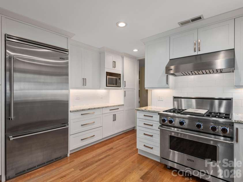 65 Cliff Drive, Laurel Park, NC 28739.  MLS# CAR4394753, YatesRealty ID 39607. Viking gas range, built-in refrigerator, granite countertops, and custom cabinetry.