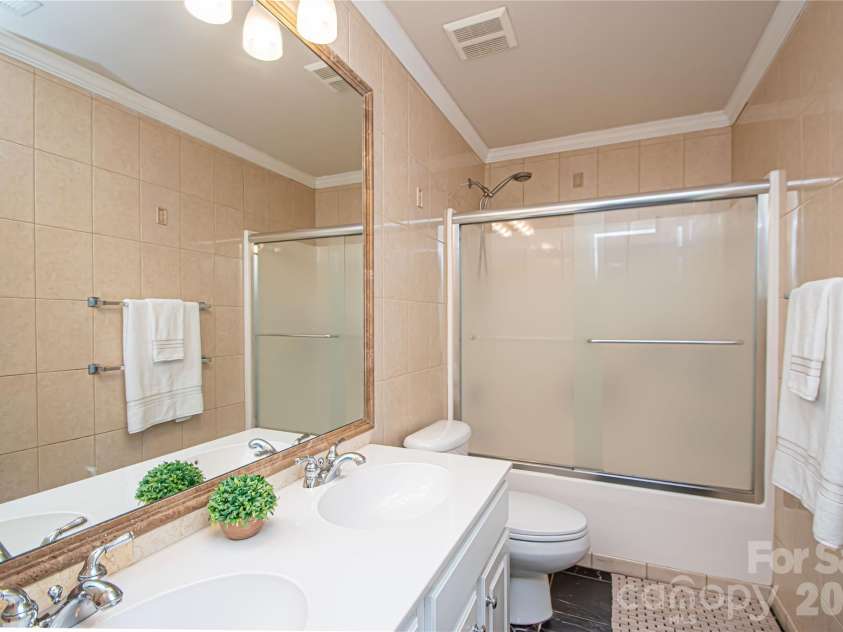 14114 Eldon Drive, Charlotte, NC 28277.  MLS# CAR4406225, YatesRealty ID 39773. Well-appointed hall bath with a stylish tile shower surround and double sink vanity