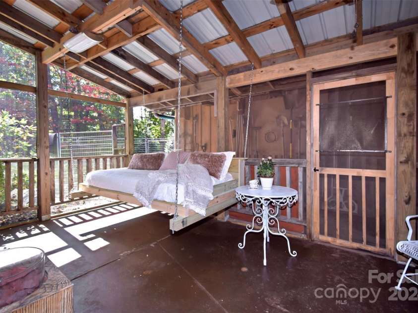 23022 Linville Falls Highway, Linville Falls, NC 28647.  MLS# CAR4178209, YatesRealty ID 3981. Custom-made swinging bed in the screened-in sleeping porch off the bedroom on lower level...the perfect spot to sneak away and take a nap!
