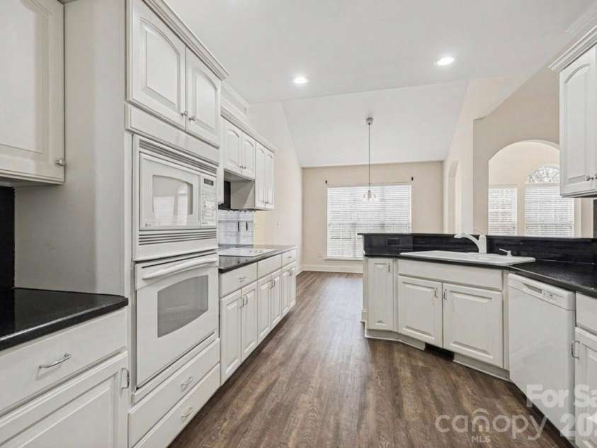 7039 Sedgebrook Drive, Stanley, NC 28164.  MLS# CAR4332906, YatesRealty ID 3987. Kitchen with black granite and a breakfast bar
