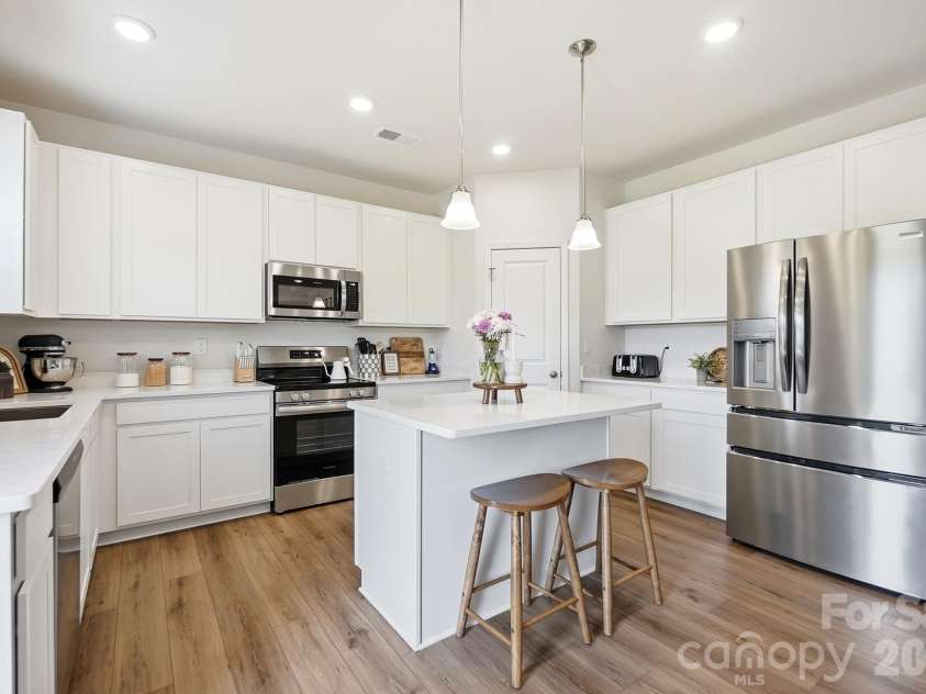 6023 Busch Way, Midland, NC 28107.  MLS# CAR4397614, YatesRealty ID 39883. Bright kitchen featuring white cabinetry, center island, and stainless appliances.
