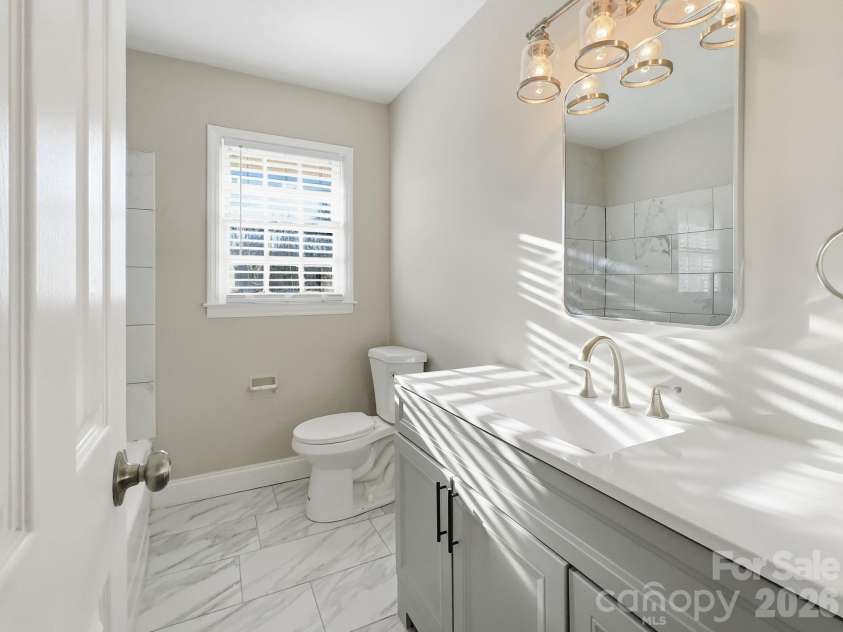 1420 Rollingwood Drive, Charlotte, NC 28217.  MLS# CAR4407002, YatesRealty ID 39902. As you begin down the hall, spacious full bath is centrally located. Highlights include a new vanity (cabinetry, sink, mirror & light fixture), gleaming tile & contemporary tile-surround wall for the tub/shower.