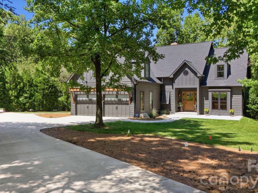 19624 Meta Road, Cornelius, NC 28031.  MLS# CAR4394341, YatesRealty ID 39952. Wide driveway and attached two-car garage create convenient everyday functionality. The front elevation shows a well-maintained exterior with mature landscaping and a private setting.