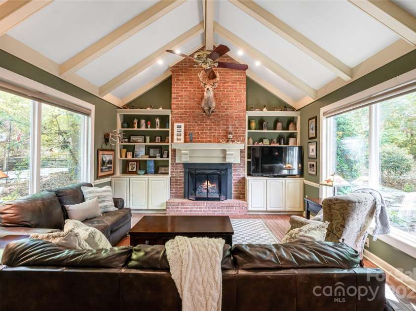 287 Anne Street, Rutherfordton, NC 28139.  MLS# CAR4258689, YatesRealty ID 3999. The den featuring large windows, a gas fireplace and access to all outdoor patio space.