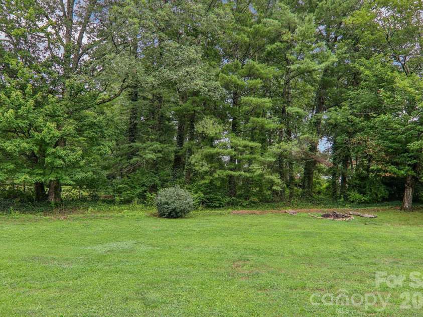 3311 Sandy Drive, Hendersonville, NC 28792.  MLS# CAR4406829, YatesRealty ID 40014. Trees in backyard