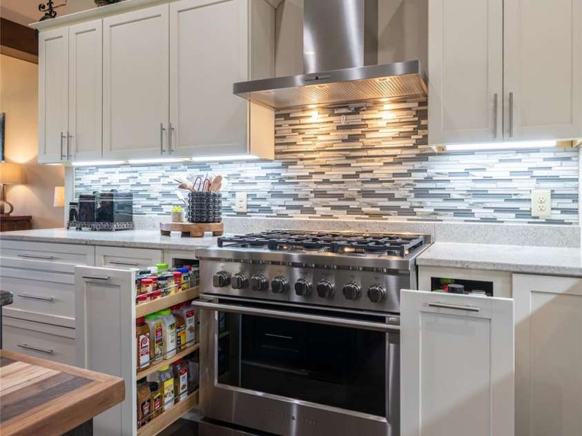 660 Pleasant Grove Road, Hendersonville, NC 28739.  MLS# CAR4406497, YatesRealty ID 40090. Dual pull-out spice drawers flank the range, offering smart storage and quick access while cooking.