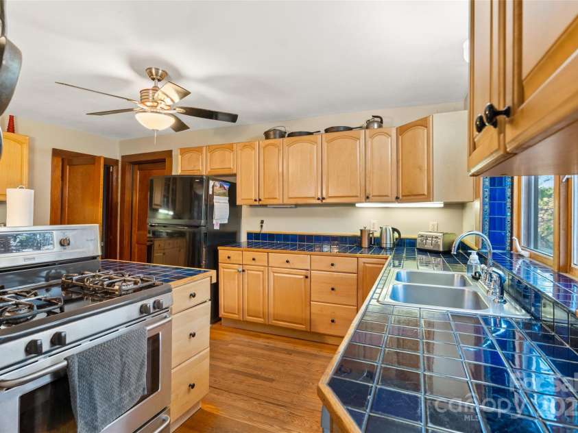 3717 Bend Of Ivy Road, Marshall, NC 28753.  MLS# CAR4209288, YatesRealty ID 401. Farmhouse main kitchen area with tiled counters and original hardwood floors