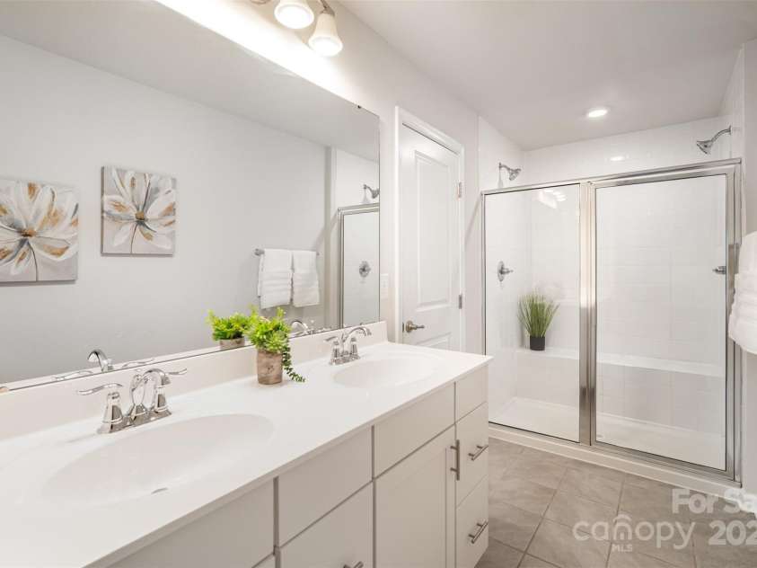 407 Park Meadows Drive, Matthews, NC 28104.  MLS# CAR4287821, YatesRealty ID 40250. Dual sinks with ample counterspace.  The walk in shower also offers twin shower heads for that spa-like experience.