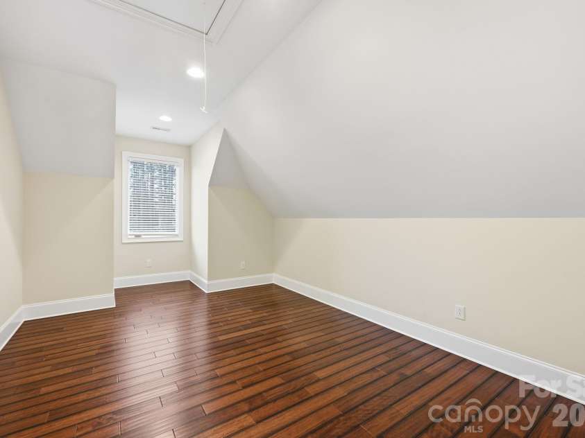 108 Washam Road, Mooresville, NC 28117.  MLS# CAR4334255, YatesRealty ID 4048. BR 4 Bright and versatile bedroom or bonus room with vaulted ceilings, hardwood floors, and neutral walls. A window provides natural light, creating a clean, open space ideal for a guest room, office, or flex area.