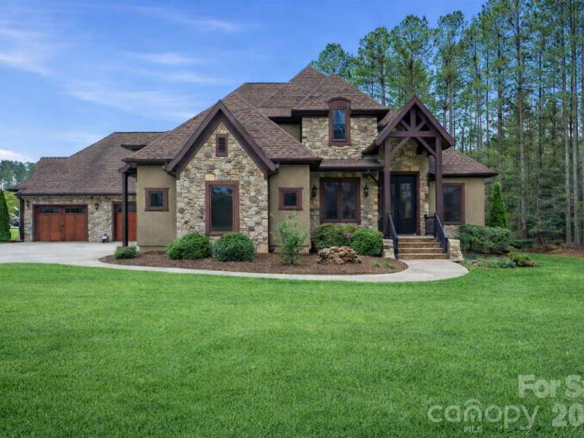108 Washam Road, Mooresville, NC 28117.  MLS# CAR4334255, YatesRealty ID 4048. Custom home featuring stone accents, brick trim, and a dramatic covered entryway.