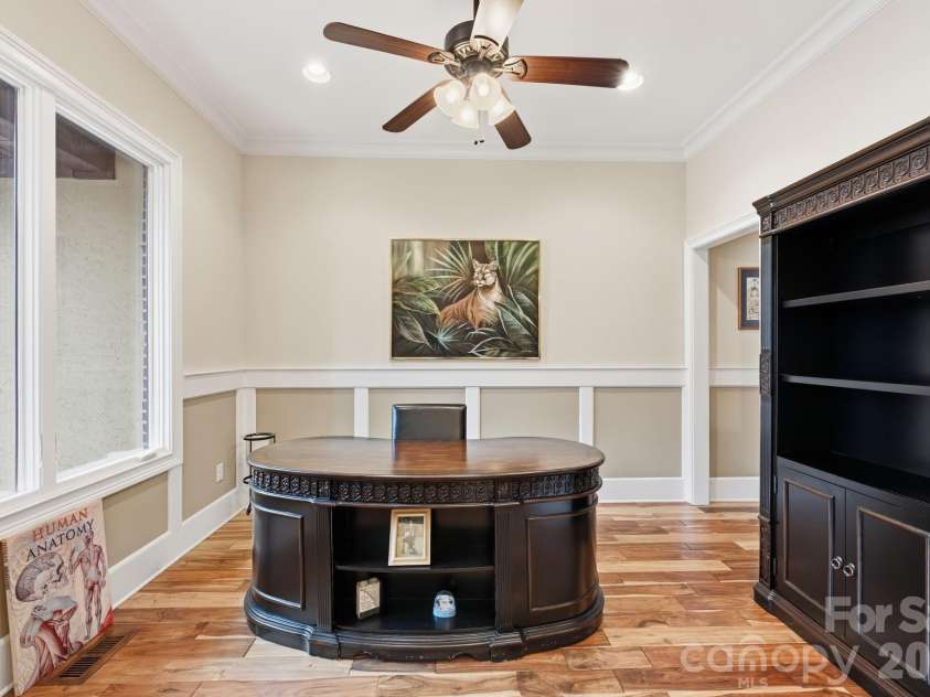 108 Washam Road, Mooresville, NC 28117.  MLS# CAR4334255, YatesRealty ID 4048. Elegant dining room with hardwood floors, crown molding, wainscoting, and ample natural light, offering a versatile space for formal dining