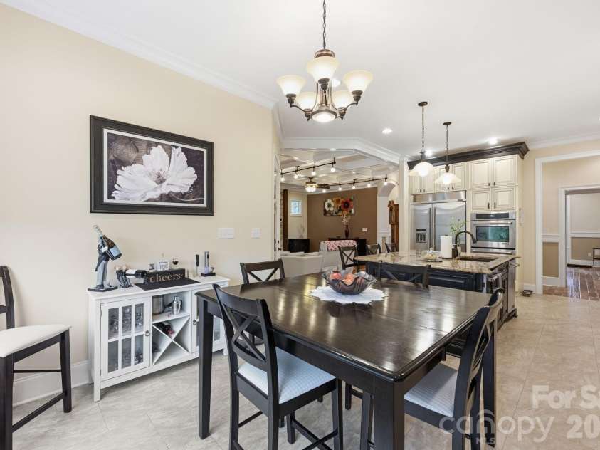 108 Washam Road, Mooresville, NC 28117.  MLS# CAR4334255, YatesRealty ID 4048. Open and inviting dining area featuring tile flooring, a modern chandelier, and seamless flow into the gourmet kitchen and living space. The room offers ample natural light and a functional layout ideal for both everyday 