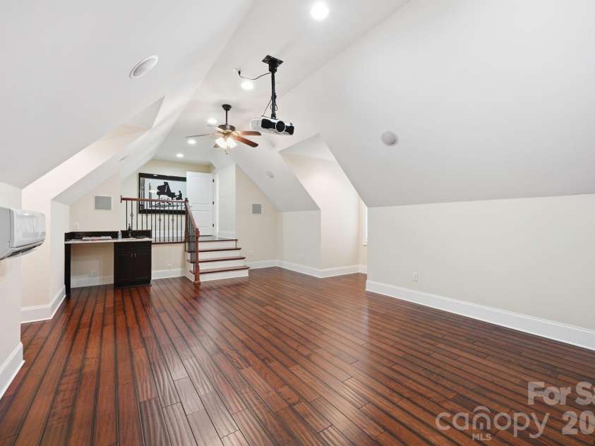108 Washam Road, Mooresville, NC 28117.  MLS# CAR4334255, YatesRealty ID 4048. Spacious bonus or media room with vaulted ceilings, hardwood floors, recessed lighting, and ceiling fan. Features built in cabinetry with sink and an open loft-style layout, perfect for a home theater, game room, or enter