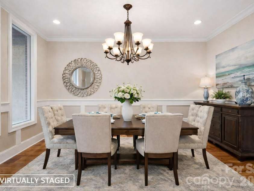 108 Washam Road, Mooresville, NC 28117.  MLS# CAR4334255, YatesRealty ID 4048. Virtually Staged Elegant dining room with hardwood floors, crown molding, wainscoting, and ample natural light, offering a versatile space for formal dining