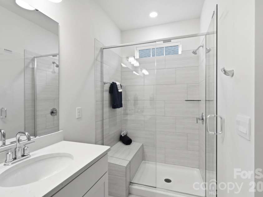 115 Shayna Road, Troutman, NC 28166.  MLS# CAR4407624, YatesRealty ID 40740. A tiled walk-in shower with bench seating creates a spa-like experience.