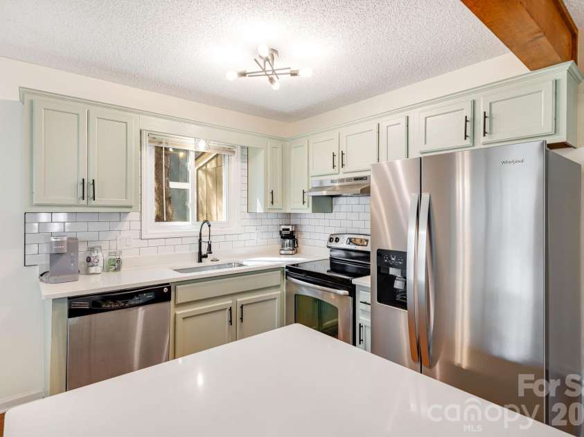 21 Susan Drive, Maggie Valley, NC 28751.  MLS# CAR4241989, YatesRealty ID 4076. Kitchen with painted cabinets, quartz countertops, SS appliances and a new undermount sink