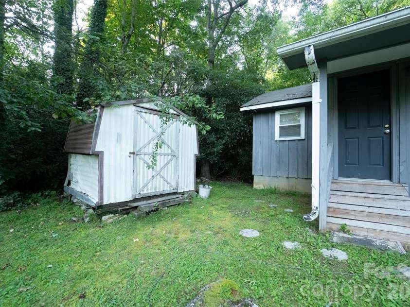 242 Whitewater Road, Sapphire, NC 28774.  MLS# CAR4410402, YatesRealty ID 40787. Left front of home/ storage shed